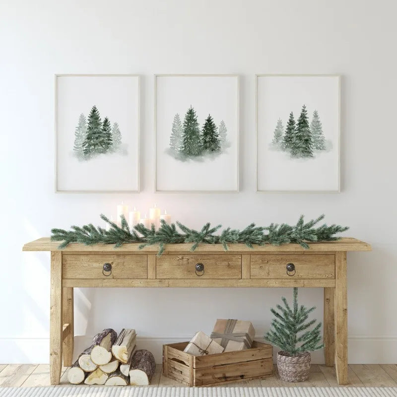 Wooden console table with decorative items against a white wall with framed tree prints.