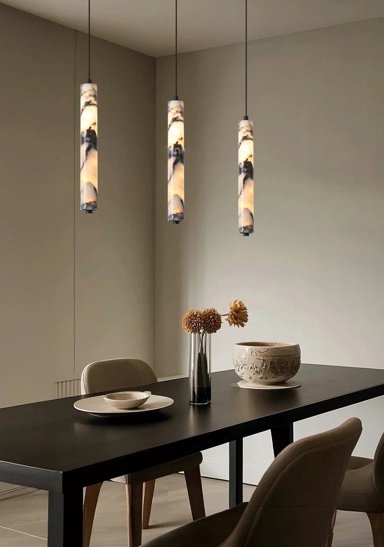 Dining room with pendant lights hanging above a table.
